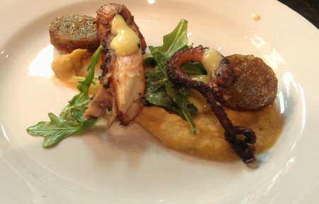 Charred octopus with smoked white bean puree, arugula with a preserved lemon vinaigrette, and cotechino sausage